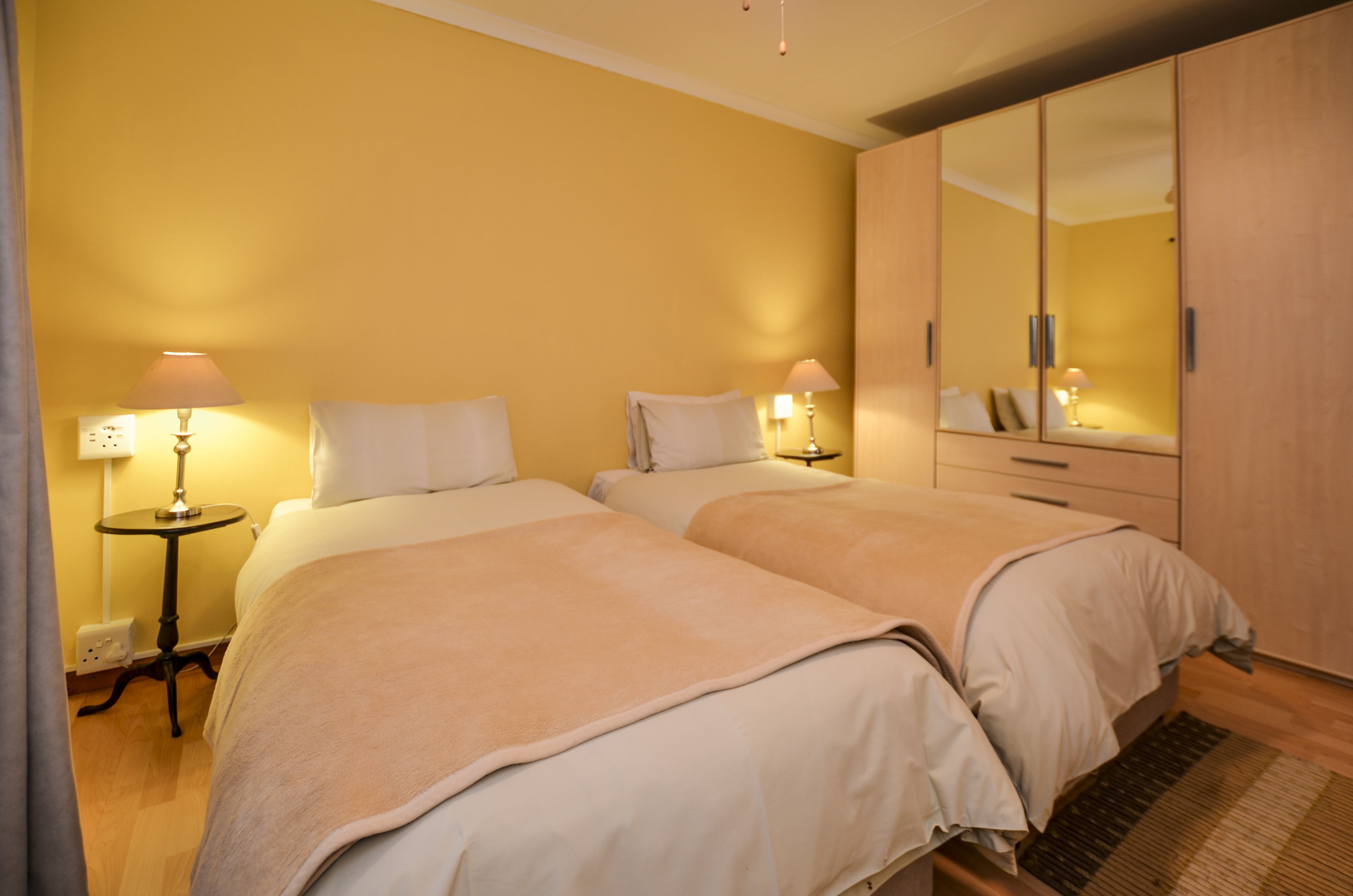 Habitació d'hotel amb dos llits, un armari i làmpades de nit.
