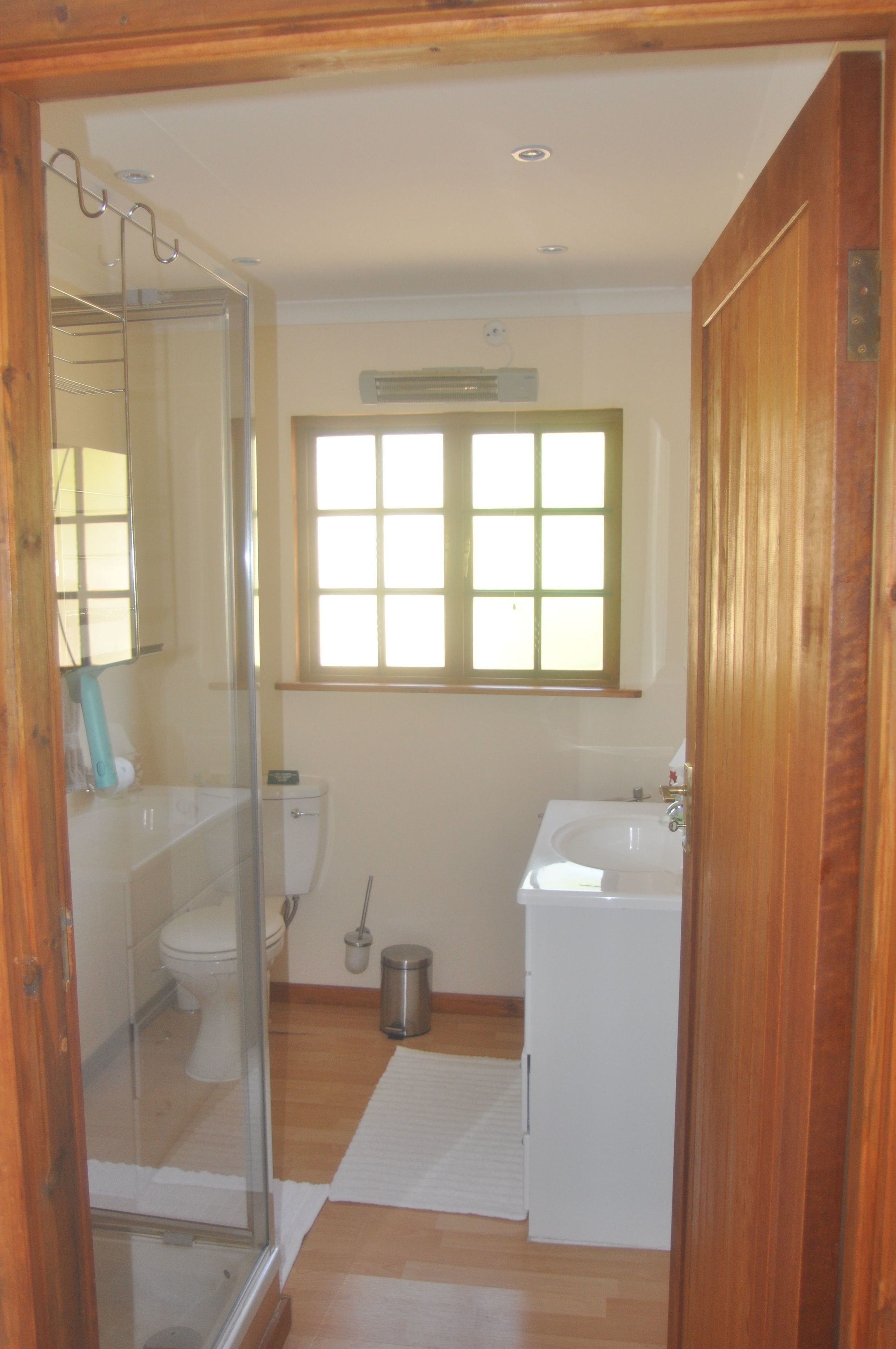 Un baño pequeño con inodoro, lavabo y ducha.