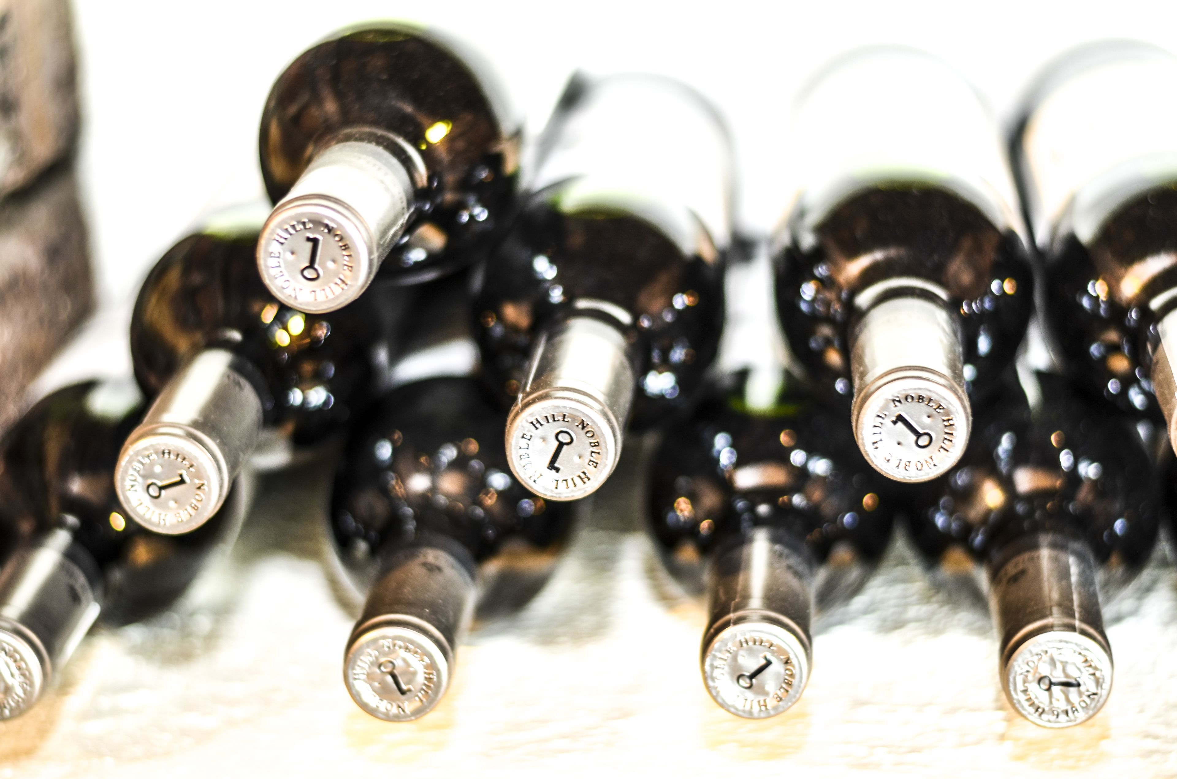 A collection of wine bottles with labels, arranged closely together.