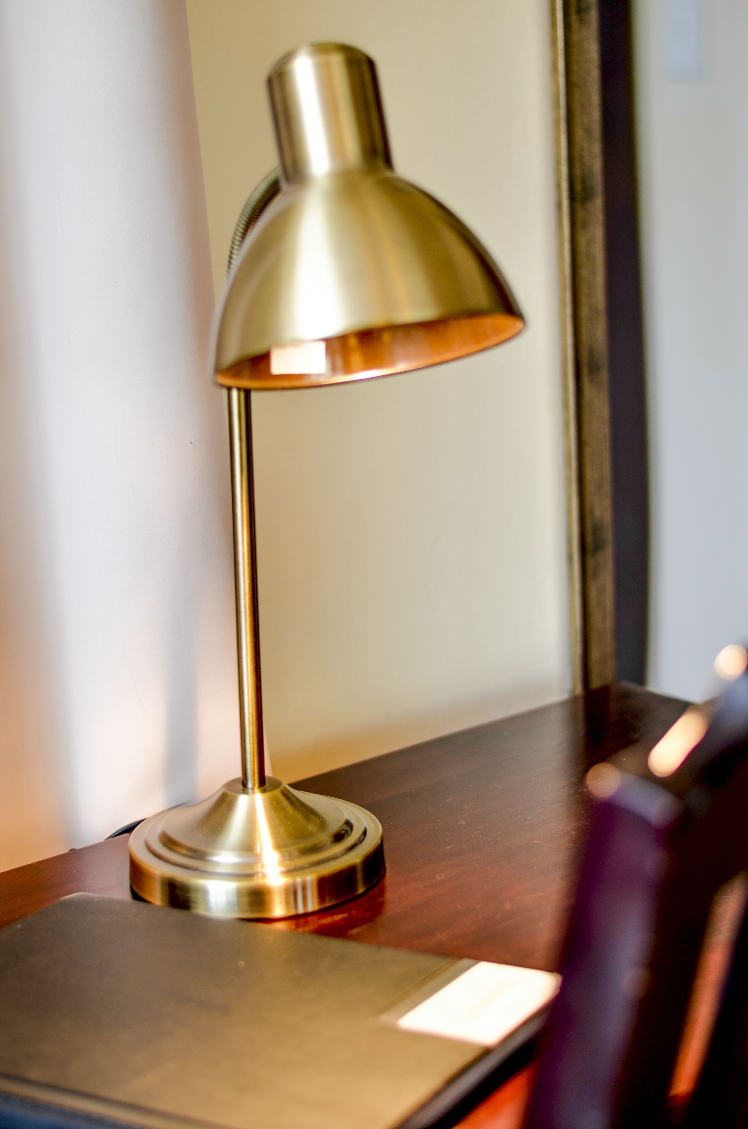 A desk lamp with a metallic finish on a wooden surface.