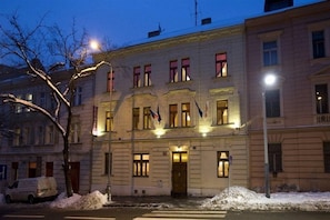 A multi-story building with a symmetrical facade, large windows, and a central entrance. - Andelapartments (Prague)
