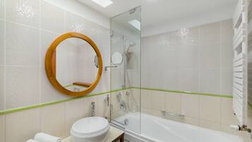 Une salle de bain moderne avec un miroir rond, un lavabo blanc et une baignoire.
