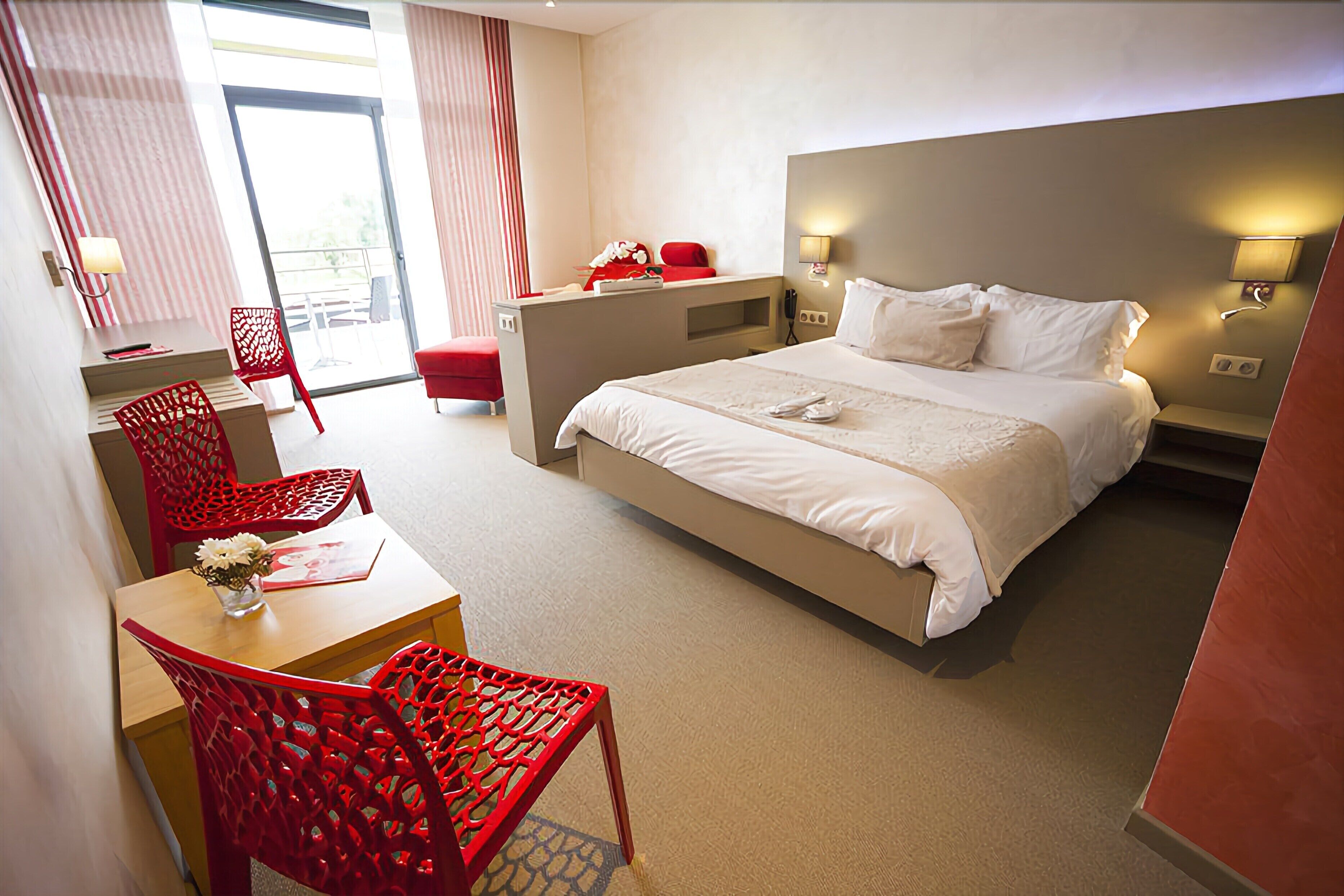 Une chambre d’hôtel avec un lit, un bureau, une chaise et une petite table.