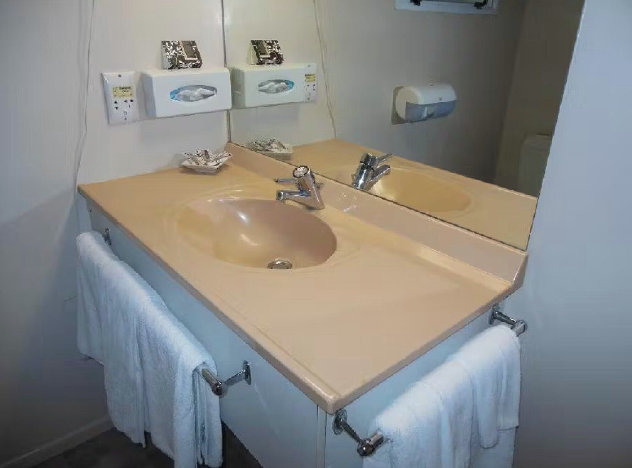 Ein Badezimmer mit zwei Waschbecken, einem Spiegel und einem Handtuchhalter.