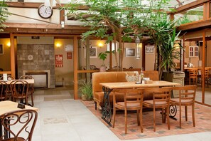 Un restaurante acogedor con muebles de madera, una chimenea y un gran árbol en el centro.