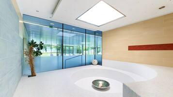 Relax in a spacious room with a large bathtub and a view of lush greenery.