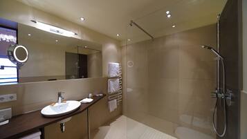 A modern bathroom with a sink, mirror, and shower.