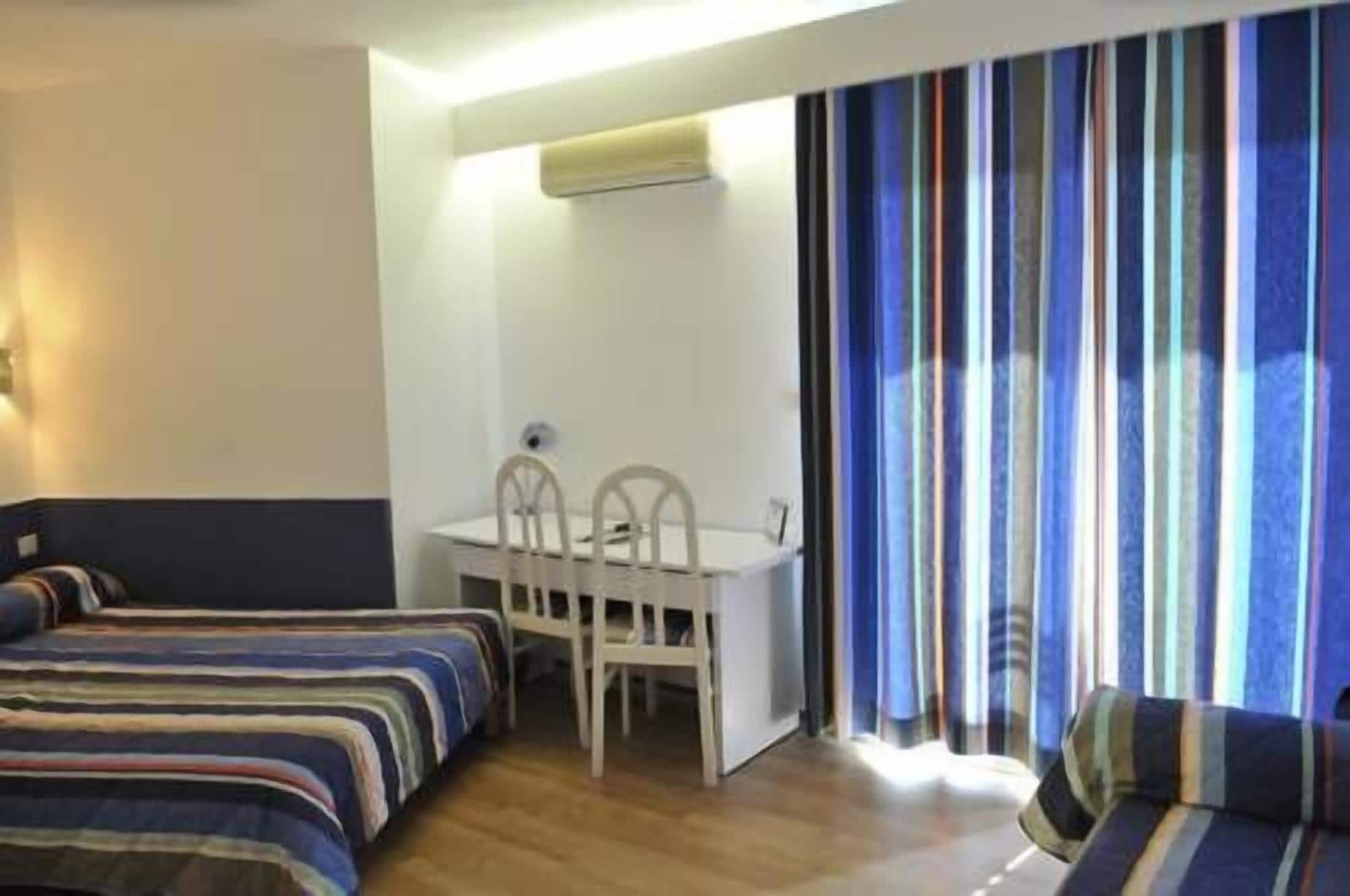 Una habitación de hotel con una cama, un escritorio y una silla.