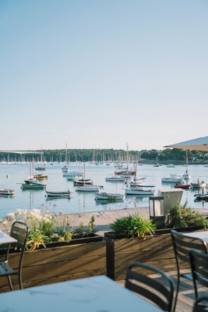 A marina with multiple boats docked, a clear sky, and a view of the water. - Hotel Et Bistrot Du Bac (Combrit)