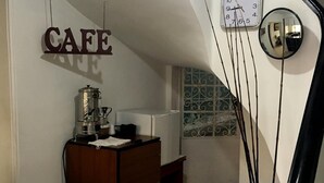 Ein Cafébereich mit einer Holztresen, einer Kaffeemaschine und einer Wanduhr.