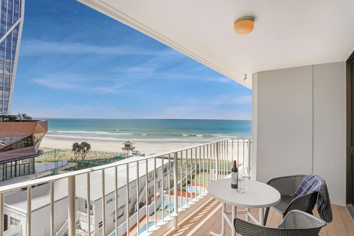 A balcony with a view of the beach and ocean.