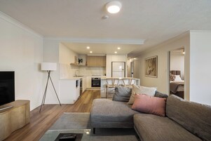 Una sala moderna con un sofá, un televisor y una lámpara.