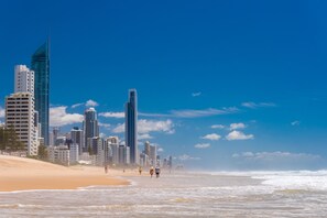 A beach with a city skyline in the background. - Breakers North Absolute Beachfront Apartments (Surfers Paradise)