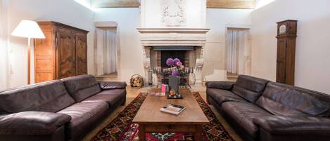 A room with two leather sofas, a wooden coffee table, and a colorful rug.