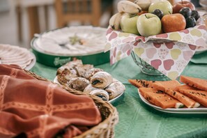 A table with various food items including fruits, pastries, and a green tablecloth. - Aqua Therm Hotel (Zalakaros)