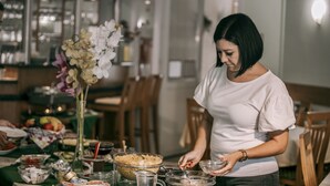 Un'area pranzo con un tavolo apparecchiato per un pasto, inclusa una ciotola di cibo, una brocca e diversi piatti.
