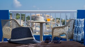 A balcony with a hat, sunglasses, and a table with a drink. - Belvedere Village (Malevizi)