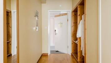 A hallway with wooden flooring and built-in closets on both sides.