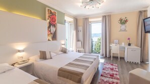 Habitación de hotel con una cama grande, un escritorio, una silla y vistas al exterior.
