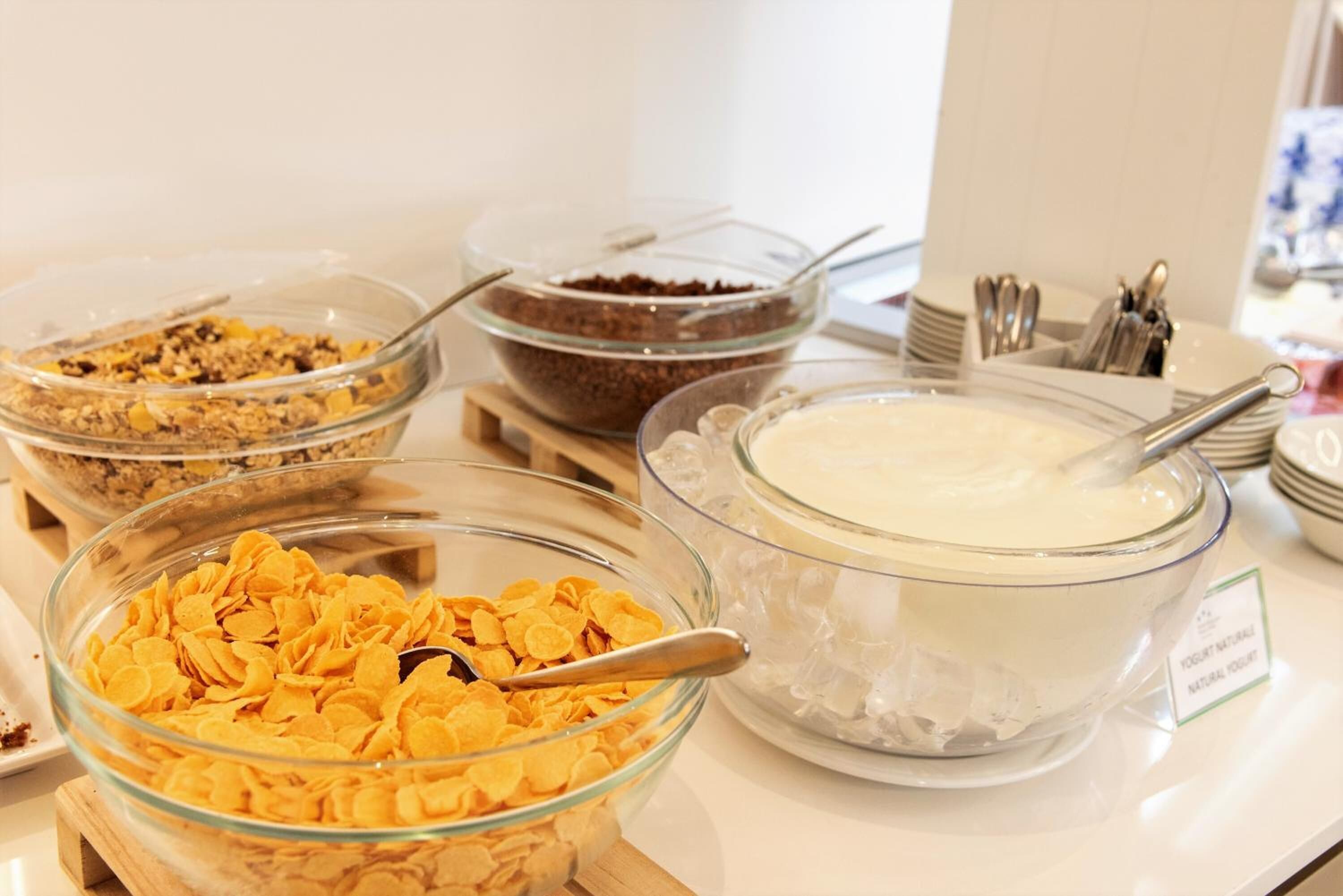Ein reichhaltiges Buffet mit verschiedenen Speisen, darunter Müsli, Schokolade und Joghurt.