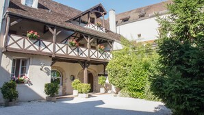 Un bâtiment traditionnel à colombages, doté d’un balcon, de plantes en pot et surplombant un ciel dégagé.