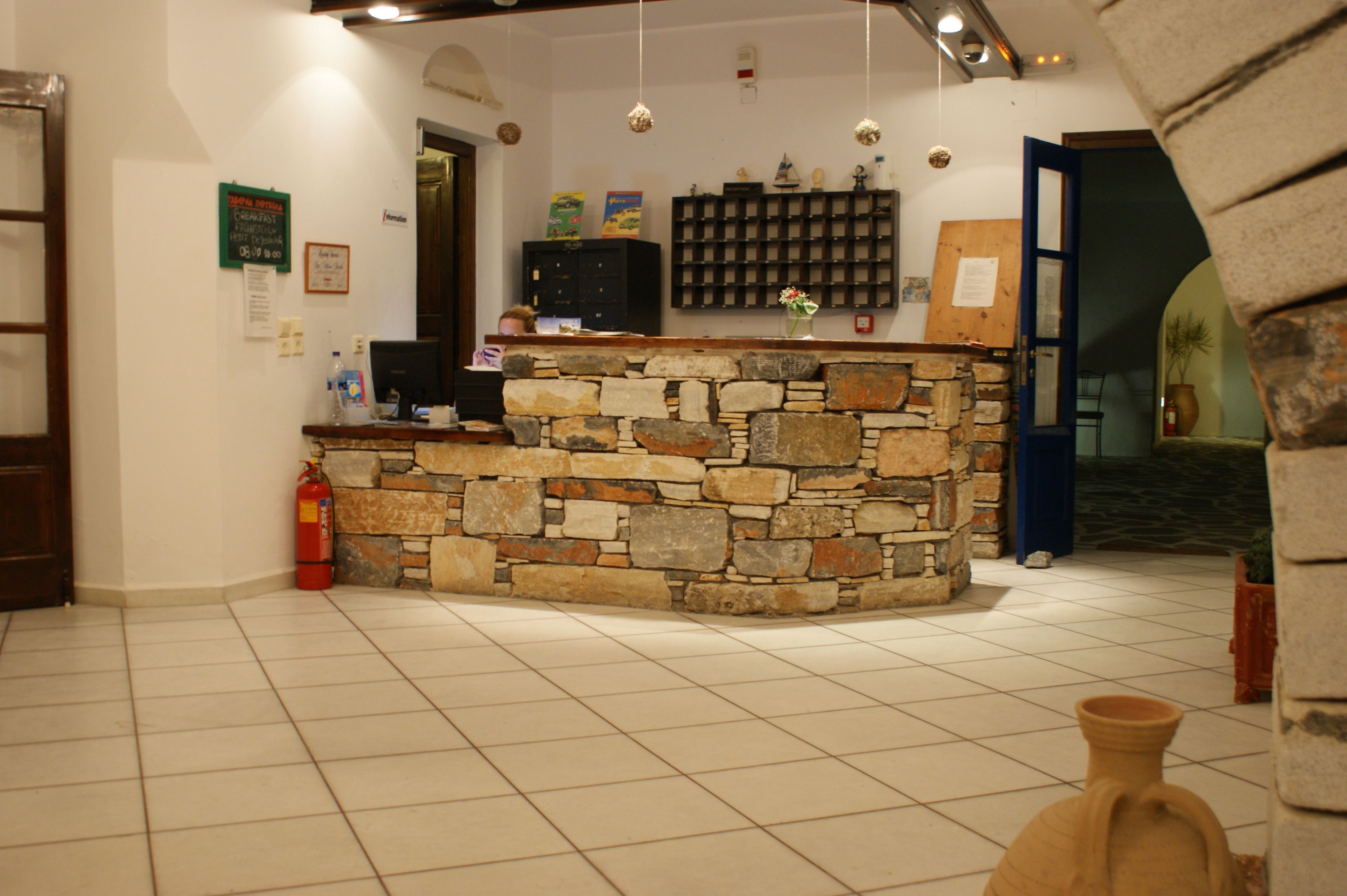 A reception area with a stone counter, tiled floor, and a fire extinguisher.