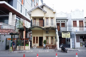 A two-story building with a balcony, a motorcycle parked in front, and a signboard with contact information. - Khresna Guest House Malioboro (Yogyakarta)