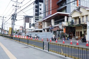 A street view with buildings, a sidewalk, and a pedestrian crossing. - Khresna Guest House Malioboro (Yogyakarta)
