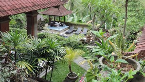 A lush garden with a gazebo, seating area, and various plants. - Nick's Hidden Cottages (Ubud)