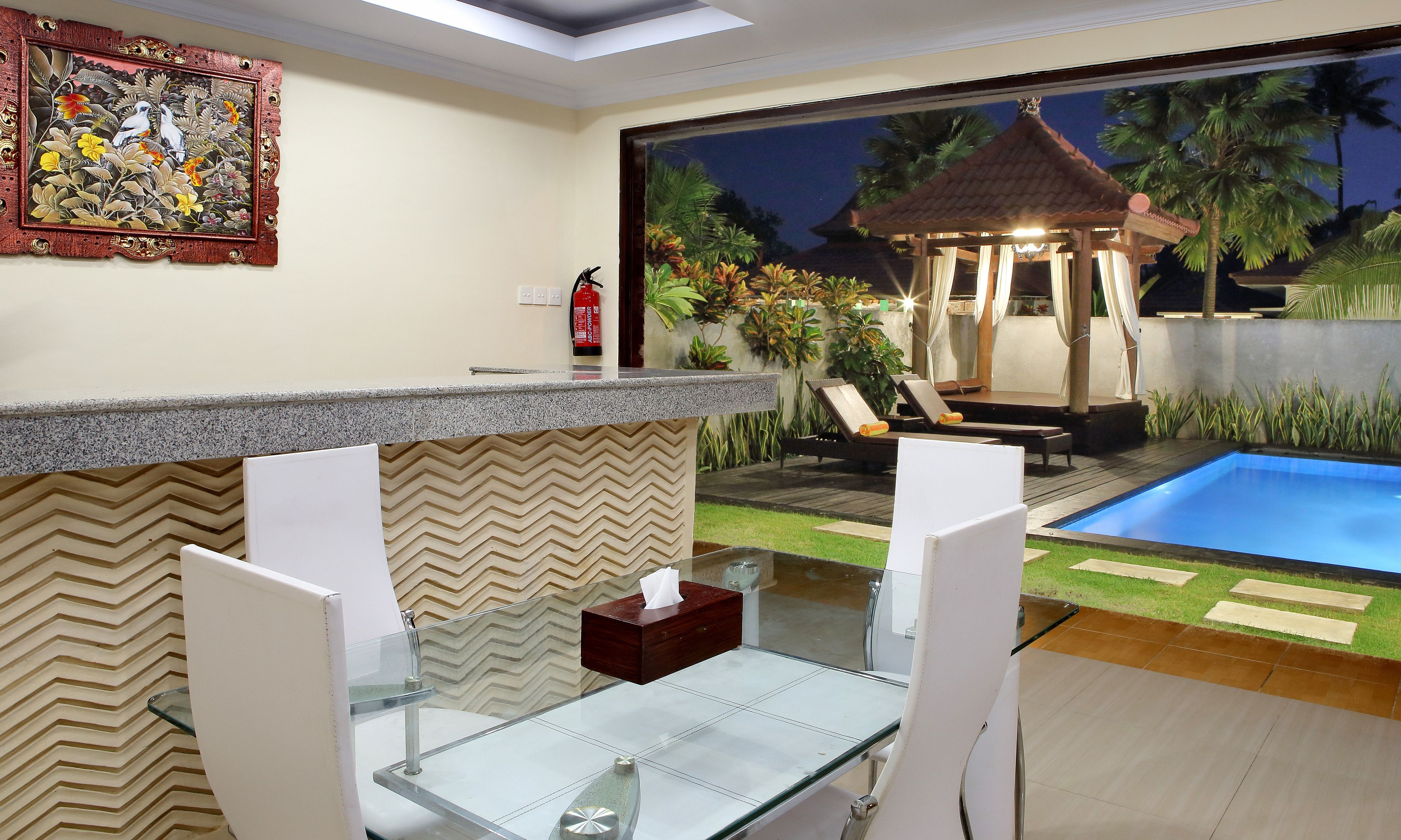 Uma área na piscina com mesa de vidro, cadeiras de descanso e um gazebo.