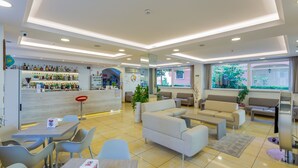 A modern hotel lobby with a bar area, seating arrangements, and large windows. - Monica (Rimini)