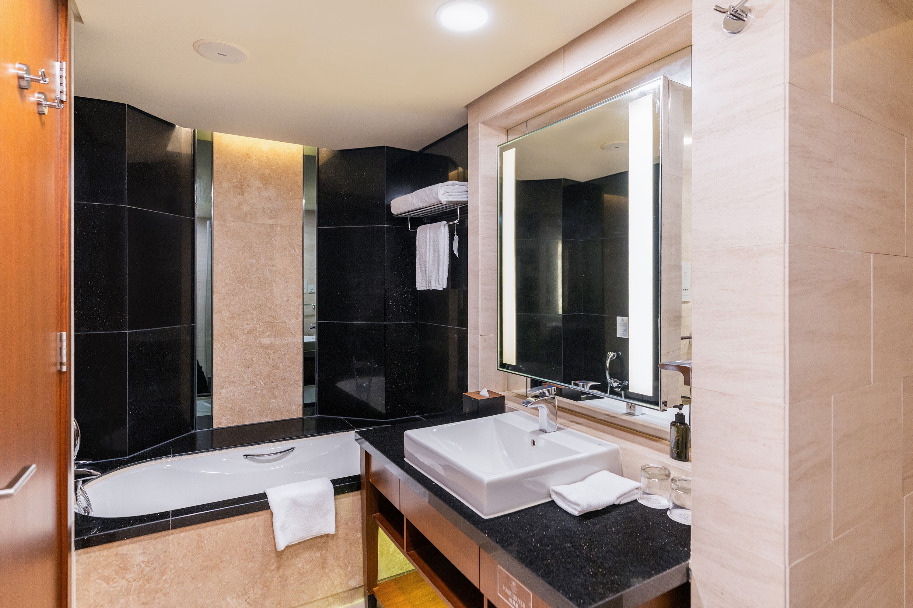 A modern bathroom with a double sink, a large mirror, and a shower area.