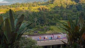 Un cours de yoga sur un toit, avec vue sur un paysage montagneux.