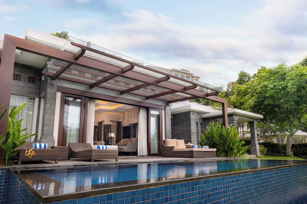 A modern house with a swimming pool, outdoor seating, and a covered patio.