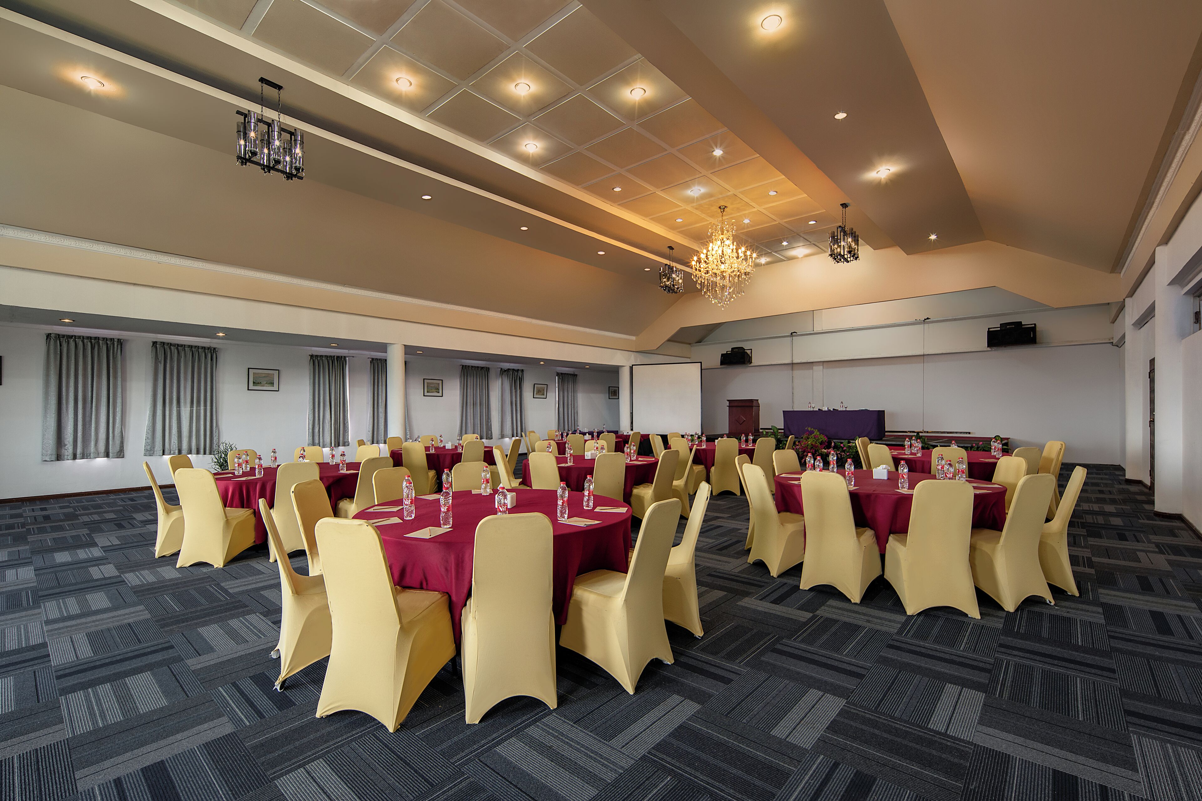 A conference room with multiple tables and chairs, equipped with water bottles and nameplates.