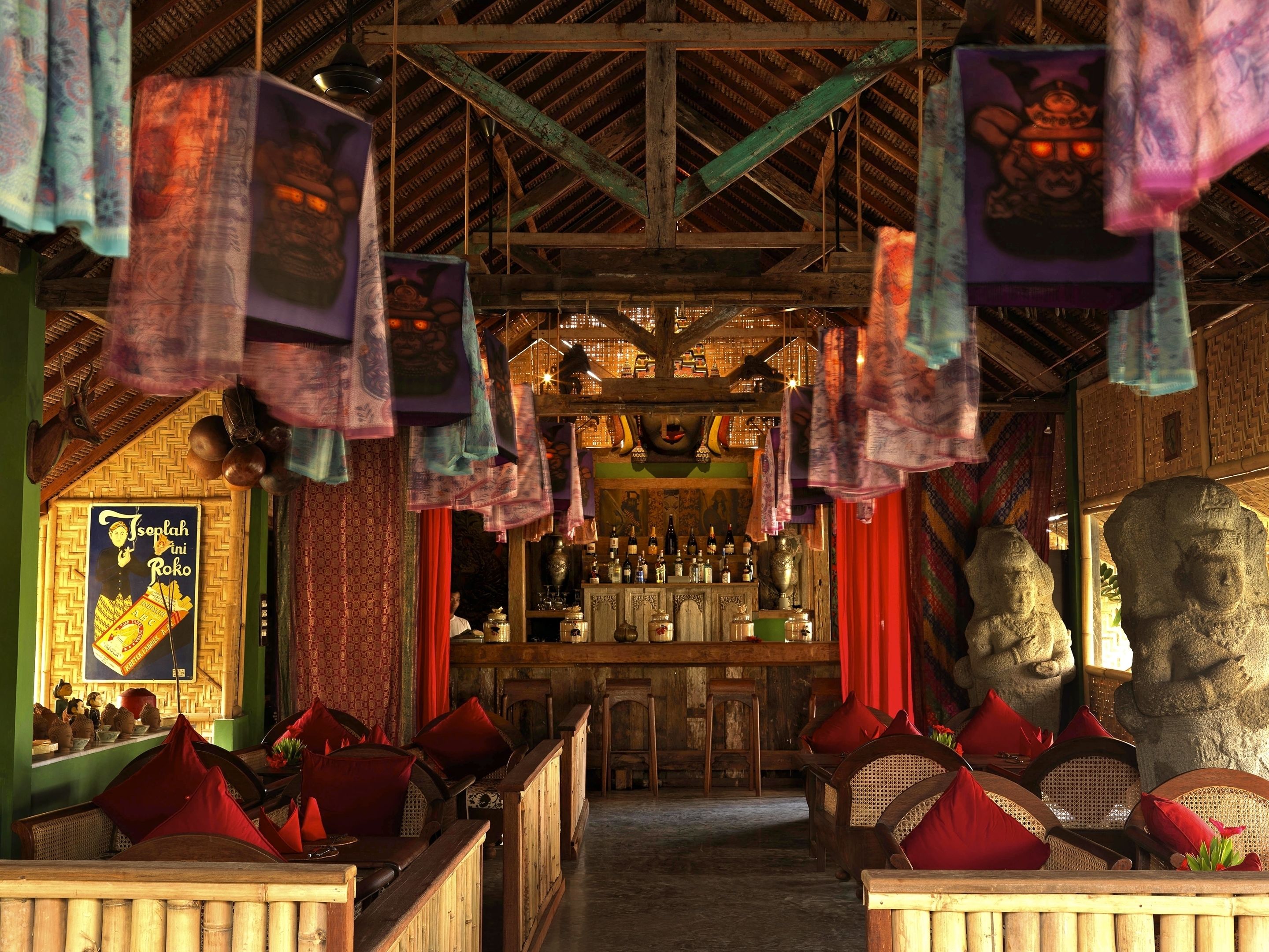 A traditional bar with wooden furniture and hanging decorations.