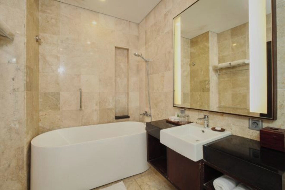 A modern bathroom with a freestanding bathtub, a vanity with a mirror, and a shower area.