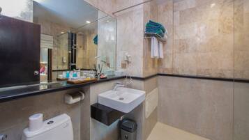 A modern bathroom with a glass shower enclosure, a sink, and a toilet.