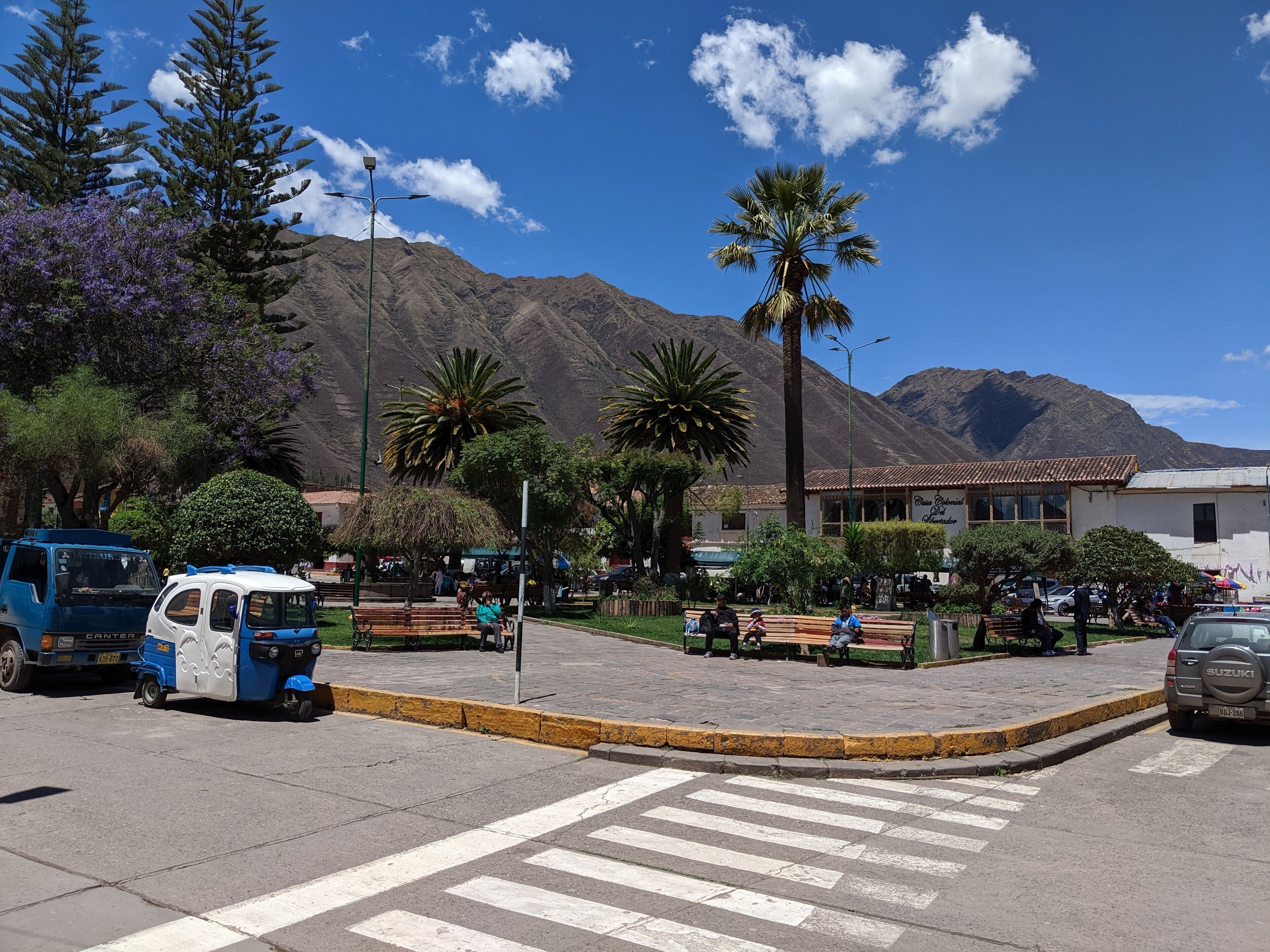 Vista de una calle con vehículos, un paso de peatones y un edificio con un letrero que dice 'Casa del Pueblo'.