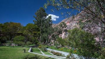 Un parque con senderos, árboles y montañas al fondo.