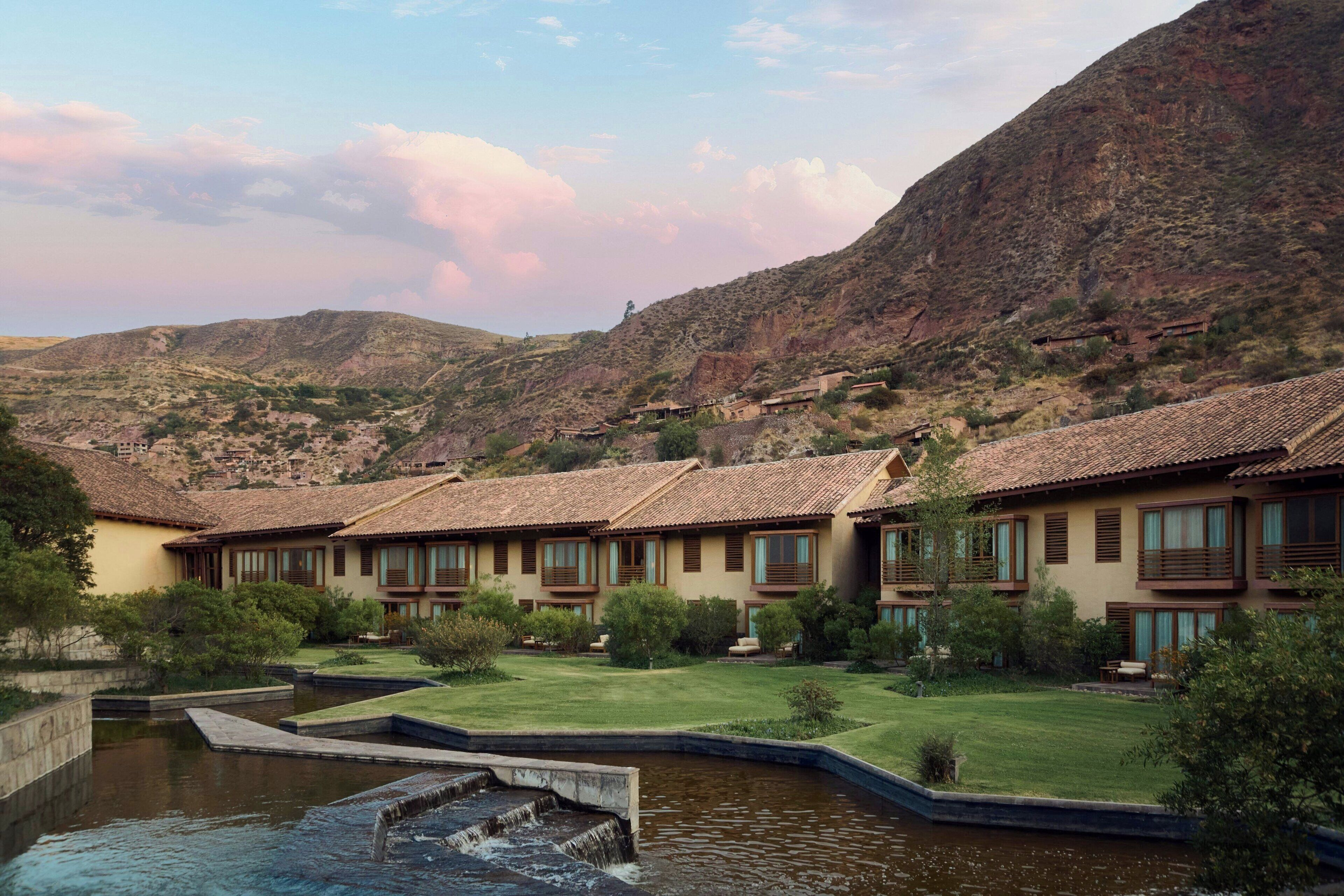 A hotel with multiple buildings, a courtyard, and a small water feature.