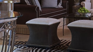 A luxurious hotel room with a large bed, a sofa, a coffee table, and a zebra-patterned rug. - Delamar Southport (Southport)