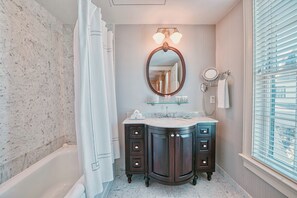 Een bad/douchecombinatie, designer toiletartikelen, een haardroger
