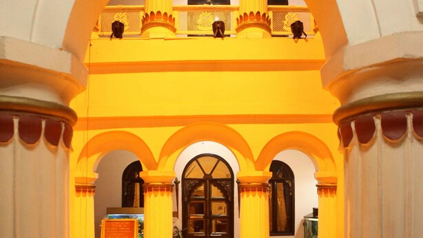A grand entrance with a central door flanked by columns, leading to a balcony with railings. - The Fort Ramgarh (Panchkula)