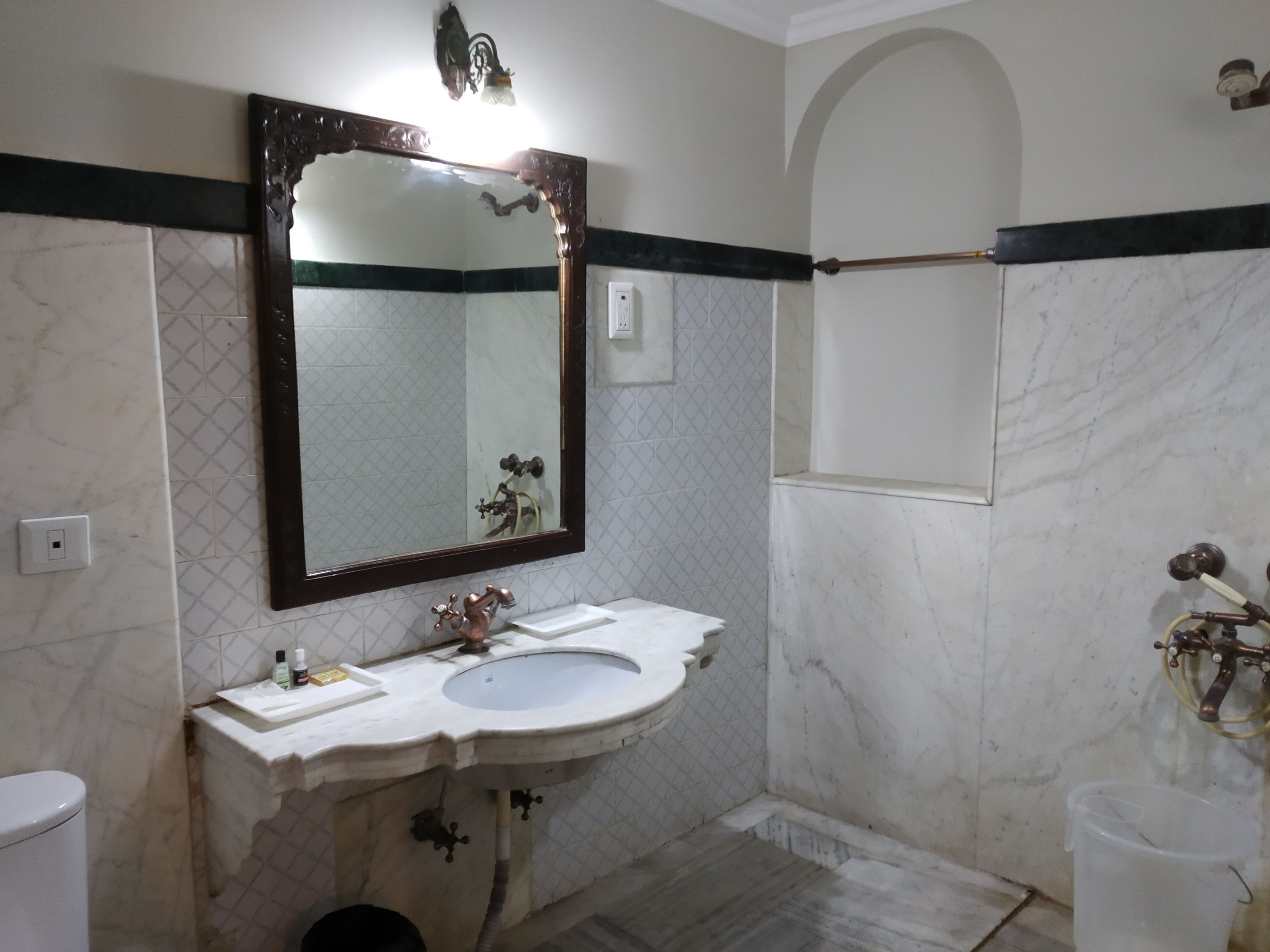A bathroom with a marble sink, a large mirror, and a shower area.