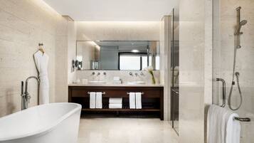 A modern bathroom with a freestanding bathtub, a double sink vanity, and a glass-enclosed shower area.