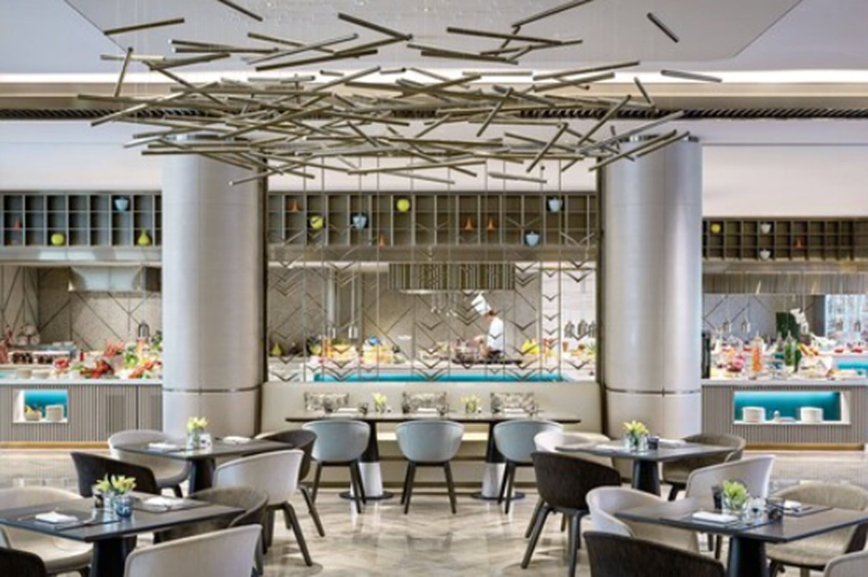 Restaurante moderno com balcão central, pé direito alto e mobiliário contemporâneo.