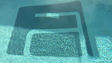 En swimmingpool med ett rektangulärt område för solbad.