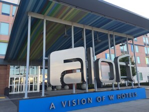 A hotel entrance with a large 'a l o o t' sign and 'A VISION OF W HOTELS' text. - Aloft by Marriott Tulsa (Tulsa)