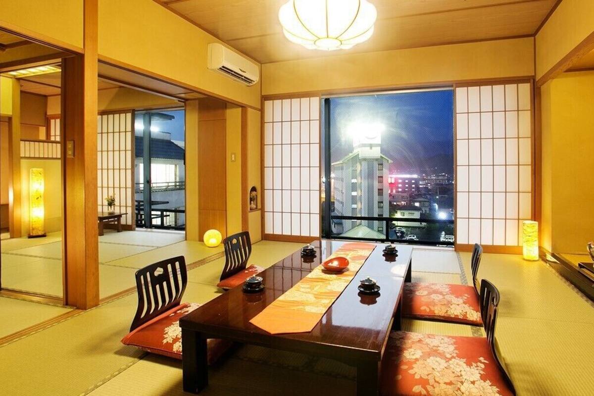 A traditional Japanese room with tatami flooring, a low table, and sliding doors.